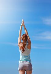 Image showing Woman, exercise and yoga for meditation with hands in air against blue sky for freedom, health and wellness outdoor. Fitness model in prayer pose for workout, mindfulness and mental health meditation