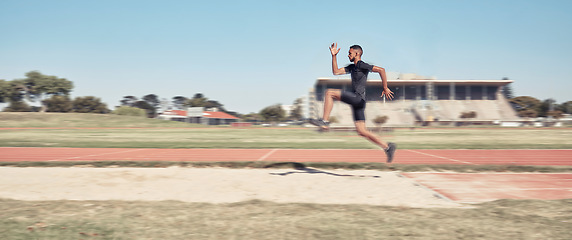 Image showing Long jump, athletics and fitness with a sports man jumping into a sand pit during a competition event. Health, exercise and training with a male athlete training for competitive track and field