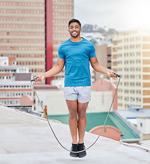 Image showing Jump rope, fitness and portrait of a man on a rooftop, sports training and cardio in the urban city. Energy, jumping and athlete skipping for wellness, workout and strong body with happiness