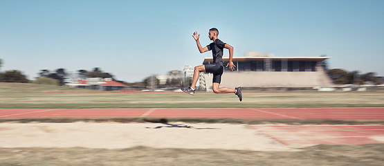 Image showing Runner, man jump and sports stadium for marathon training, fitness workout or wellness exercise on track. Athlete, speed and running energy or jumping for olympics high jump performanc and challenge
