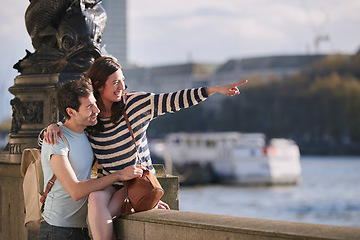 Image showing Travel, love and honeymoon with a young couple pointing while sightseeing on an overseas trip abroad together. Water, city and summer with a man and woman bonding or traveling in a foreign country