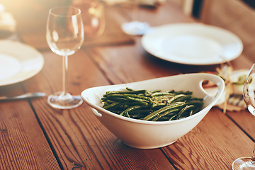 Image showing Thanksgiving, green beans and food with a place setting on a dining room table for a celebration event. Party, dish and dinner with a bowl on a wooden surface in celebration or holiday tradition