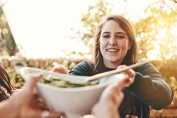 Image showing Food, salad and healthy eating outdoor with woman giving or serving bowl with vegetables on patio for Christmas or thanksgiving lunch or dinner. Family or friends together to eat at home celebration