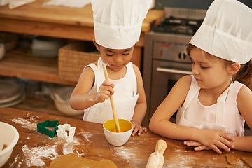 Image showing Children, learning and baking in a kitchen with girls bonding, curious and mixing egg for cake in their home. Kids, cooking and siblings having fun with cookies, recipe and development activity