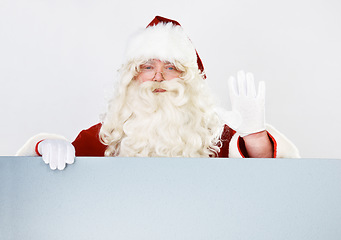 Image showing Christmas, santa and portrait with hand wave for friendly festive holiday greeting advertising. Celebration, vacation and santa claus man waving hello with white studio marketing mockup background.