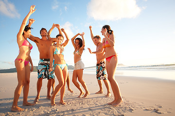 Image showing Cheerful teenagers dancing on the beach. Portrait of happy teenagers dancing on the beach.