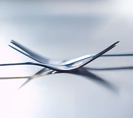 Image showing Forks, balance and utensils on a table in the kitchen for eating at a restaurant, home or house. Stainless steel, metal or silver parallel cutlery, tableware or object to eat or cook a meal.