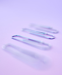 Image showing Row, paper clips and office stationery for paperwork in a studio with a purple background. Work supplies, equipment and steel wire clips in a line to organize or hold document, report or form sheets.