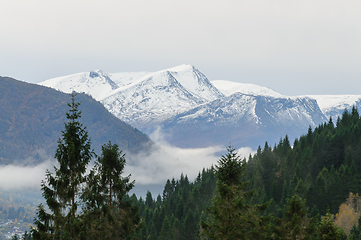 Image showing snow-capped mountain peaks above mist-covered valleys