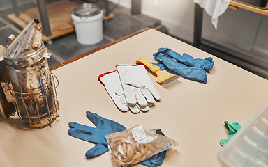 Image showing Beekeeping, bee bellows and gloves in workshop for safety, equipment or farming at apiary job. Beekeeper factory, ppe or plant for preparation, industry or warehouse in workplace at apiculture farm