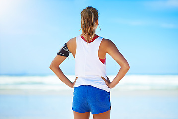 Image showing Fitness, woman runner and relax on a break at the beach for exercise, workout or training in the outdoors. Active healthy female relaxing or breathing after running or exercising by the ocean coast
