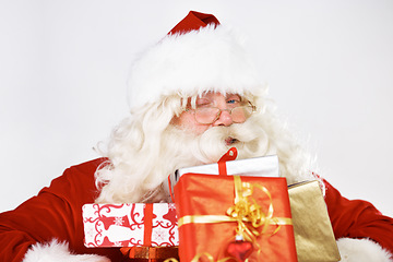 Image showing Christmas, santa and gift portrait with wink for traditional festive holiday advertising. Present, giving and santa claus man with colorful ribbon boxes on white studio mockup marketing.