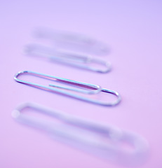 Image showing Paperclip, filing and organization for documenting or attachment in studio on a purple background. Business, office and stationery with a metal clip for file or storage purposed on a color surface