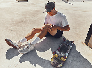 Image showing Skateboard, knee and injury with a sports man holding his leg joint in pain after a fall or accident outdoor. Fitness, skatepark and exercise with a male athlete suffering in agony while skating