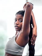 Image showing Workout, portrait and black woman stretching arm for self care, wellness and health at club. Exercise, training and athlete warm up in gym for body cardio with serious and determined face.