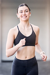 Image showing Woman runner, portrait and smile with earphones for music at training, workout or exercise in city. Young athlete girl, happy and running for health, self care or wellness while streaming on internet