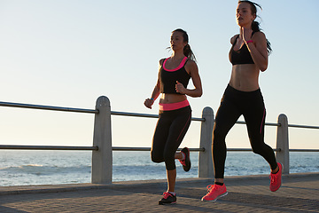 Image showing Running, beach and woman of friends with fitness goals, body wellness and teamwork on morning blue sky mockup. Accountability, personal trainer and sports, athlete or runner people training outdoor