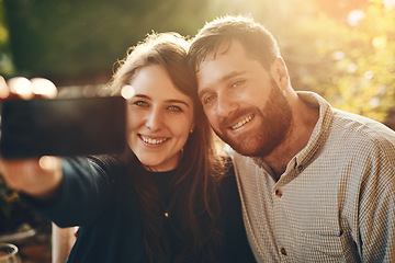 Image showing Happy, phone and couple love to take a selfie at an outdoor restaurant for a romantic date in spring. Relax, memory and young woman taking pictures with a young partner smiles on marriage anniversary