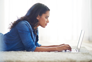 Image showing Floor, laptop and relax with a woman blogger or freelance worker doing remote work from home while lying. Computer, email and technology with a young female online working on her carpet in a house