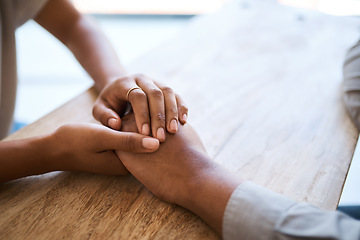 Image showing Couple, holding hands and support on table in closeup for help, care and empathy in time of grief. Black couple, helping hand and love to forgive, consult or comfort together in home with kindness