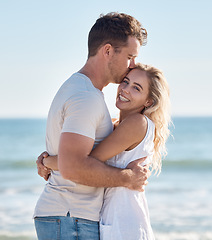 Image showing Couple, beach and hug bonding with a kiss, love and care happy about anniversary and commitment. Portrait of a girlfriend and boyfriend together on summer vacation smile feeling freedom on holiday