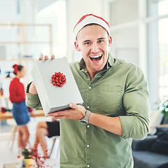 Image showing Christmas, coworking office and gift for excited and happy business man during holiday celebration with secret Santa present. Portrait of an employee holding gift box surprise at workplace event