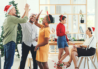 Image showing Christmas, party and high five with business people having fun in their office together during the festive season. Team, motivation and celebration with a man and woman colleague group at work