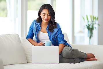 Image showing Laptop, relax with coffee and black woman on sofa reading email, checking social media or streaming movie at home. Weekend, woman on couch with computer and a coffee break in living room on internet.