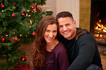 Image showing Couple, christmas and portrait together in home with smile, happiness and bonding with christmas tree. Man, woman and happy by fireplace for celebration, party and holiday spirit on living room floor