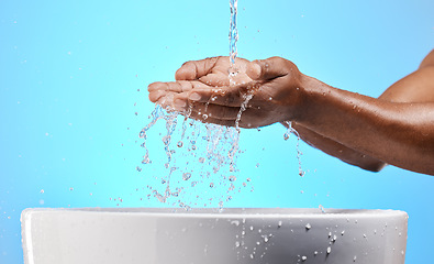 Image showing Cleaning, washing and hands with water in studio on blue background for wellness, hydration and virus safety. Skincare, health and black person washing hands for germ protection, hygiene and bacteria