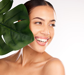 Image showing Woman, face or skincare glow with plant in organic healthcare wellness, vegan dermatology or healthy Brazilian cosmetics. Smile, happy or beauty model with monstera leaf on studio background mock up