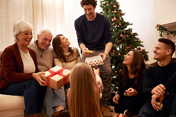 Image showing Christmas, happy and gift with family in living room for for celebration, holiday and festive gratitude. Relax, smile and present with parents giving box to children at home for content on xmas party