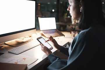 Image showing Phone, computer and night with a business woman typing a text message while working late in her office. Ecommerce, networking and communication with a female employee putting in overtime at work