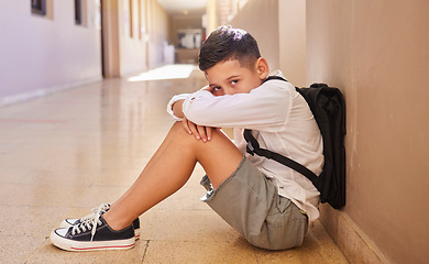 Image showing School child, bullying and sad student on ground for depression, anxiety and autism or learning problem in hallway. Boy feeling stress and depressed after abuse, violence or discrimination portrait