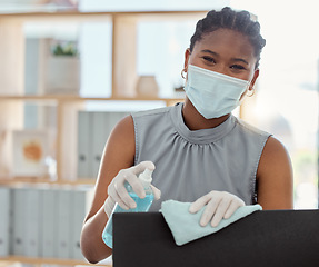 Image showing Covid, mask and sanitizer with a business black woman cleaning her computer and office equipment at work. Portrait, sanitizing and wipe with a female employee during the corona virus pandemic