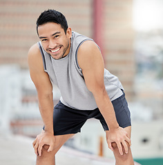 Image showing Tired, fitness and man rest on roof in city after outdoor sports workout, health motivation and training outside. Blurred cityscape background, urban athlete and personal trainer rest after exercise