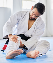 Image showing Injury, karate and man with knee pain after an accident in martial arts training in a wellness studio or dojo. Fitness, taekwondo and fighter with leg pain, emergency or joint pain after a workout