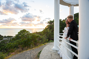 Image showing Newlyweds in a gazebo with columns on the seashore