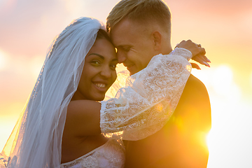 Image showing Happy newlyweds hugging in the rays of the setting sun