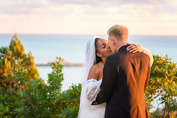 Image showing Happy newlyweds hugging against the backdrop of a seascape