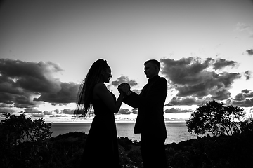 Image showing Happy young couple in backlight against sunset background, black and white version