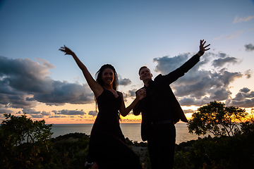 Image showing Happy young couple backlit against sunset background