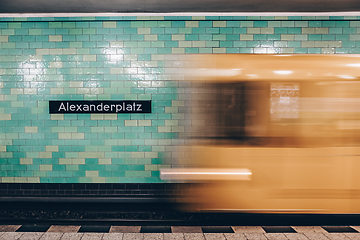 Image showing Yellow subway train in motion on Berlin Alexanderplatz underground station.