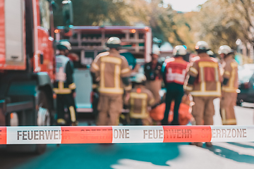 Image showing Team of firefighters by firetruck on accident location.