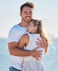 Image showing Love, beach hug and couple smile on romantic ocean holiday trip together for relationship bonding, romance and peace. Face of happy man, woman with a smile and nature summer water vacation by the sea