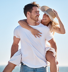 Image showing Piggy back, love and couple at a beach for a happy anniversary vacation or honeymoon holiday adventure. Smile, romance and healthy woman enjoys quality time or bonding with a romantic partner at sea