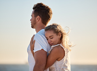 Image showing Couple, hug back and woman at beach with love, smile or happiness for anniversary, honeymoon or vacation by sea. Happy couple, man and girl in ocean wind, happy or bonding together in summer sunset