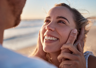 Image showing Face in hands, couple and love with trust and care, travel to beach on romantic vacation for bonding and relationship. Happy, woman smile at man with romance and adventure, date or holiday by ocean.