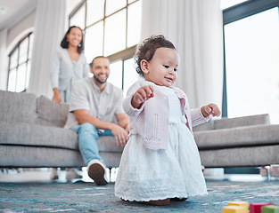 Image showing Baby, family and love with a girl learning or walking in the living room of her home with parents watching. Kids, floor and walk with a daughter taking her first steps with mom and dad in the house