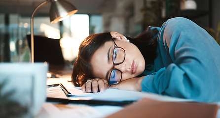 Image showing Tired, burnout and sleep with a business woman sleeping on desk while working on a computer at a desk in his office. Mental health, problem or exhausted with a young female employee at work at night